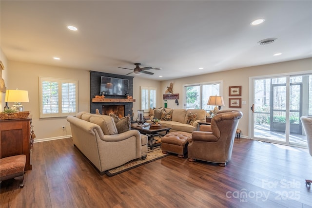 living room featuring a fireplace, ceiling fan, and dark hardwood / wood-style floors