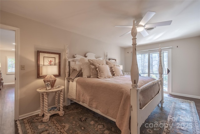 bedroom with ceiling fan, access to exterior, multiple windows, and dark wood-type flooring