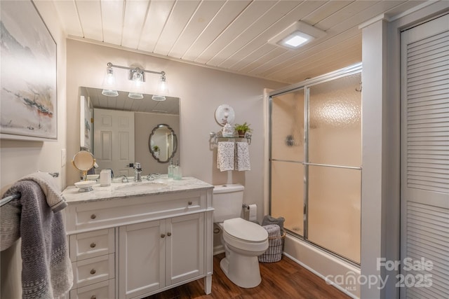 bathroom with toilet, wood ceiling, wood-type flooring, an enclosed shower, and vanity