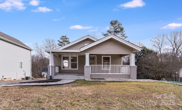 view of front facade with central AC, a front yard, and covered porch