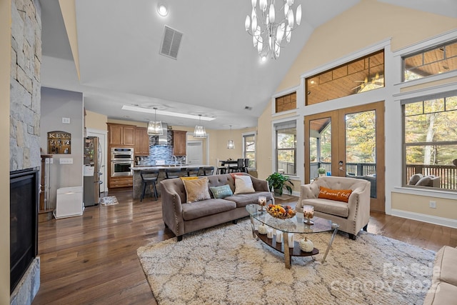 living room with high vaulted ceiling, dark wood-type flooring, french doors, and a fireplace