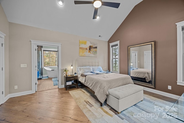 bedroom featuring ceiling fan, lofted ceiling, connected bathroom, and light hardwood / wood-style floors