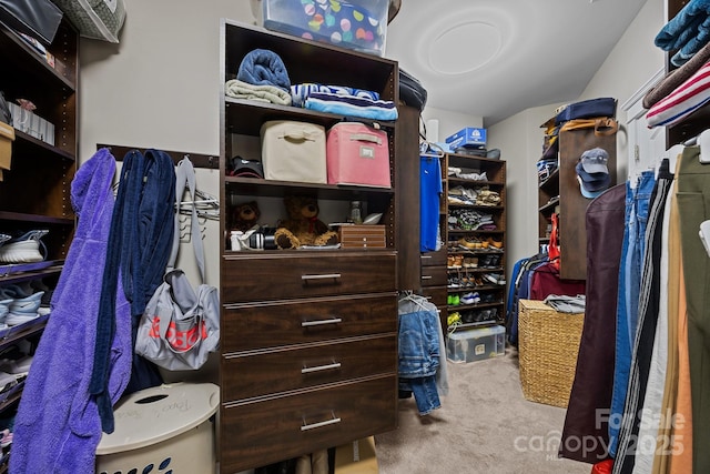 walk in closet featuring light colored carpet