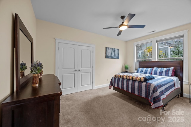 bedroom featuring ceiling fan, light colored carpet, and a closet