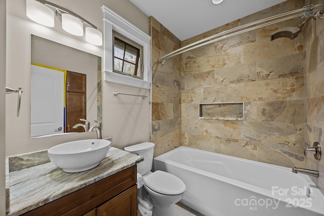 full bathroom featuring toilet, vanity, and tiled shower / bath