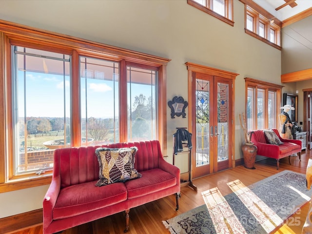 living room with plenty of natural light, hardwood / wood-style floors, and french doors