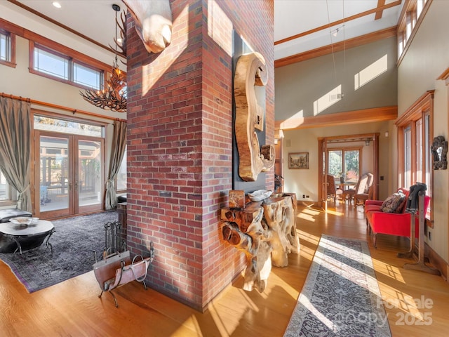 foyer entrance featuring high vaulted ceiling, french doors, a chandelier, beam ceiling, and light hardwood / wood-style flooring