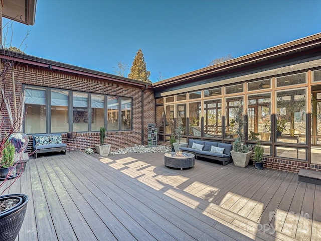 wooden terrace with an outdoor living space with a fire pit