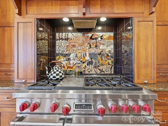 kitchen with stone counters, high end stainless steel range, and decorative backsplash