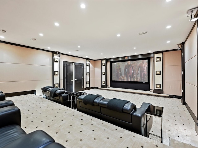 carpeted home theater room with crown molding