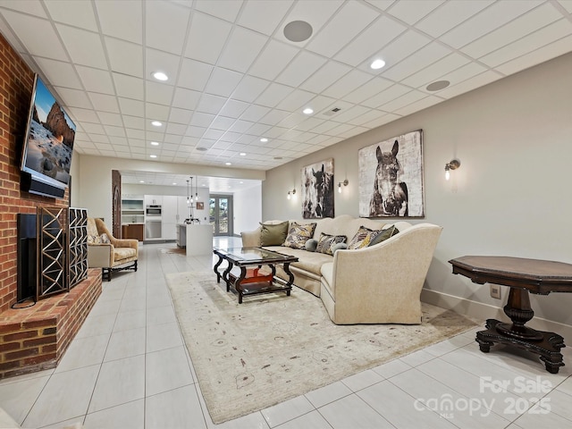 living room with tile patterned floors, a fireplace, and a drop ceiling