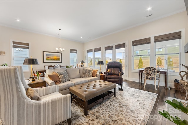 living room with ornamental molding, dark hardwood / wood-style floors, and a notable chandelier