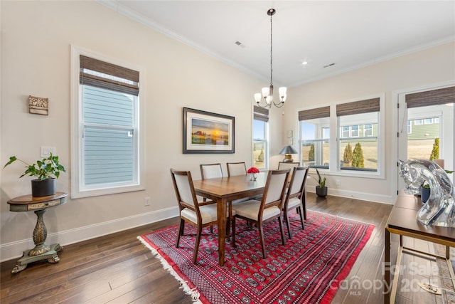 dining area featuring an inviting chandelier, crown molding, and dark wood-type flooring