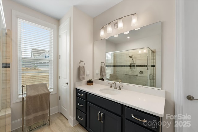 bathroom with hardwood / wood-style flooring, vanity, and a shower with shower door