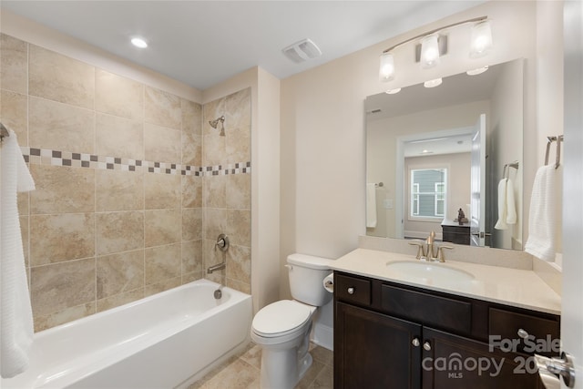 full bathroom with tiled shower / bath, vanity, and toilet