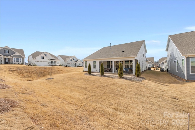 rear view of house with a yard and a patio