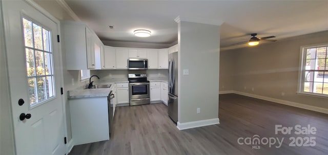 kitchen featuring a wealth of natural light, stainless steel appliances, white cabinets, and sink