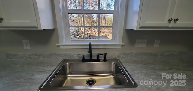 room details featuring sink and white cabinetry