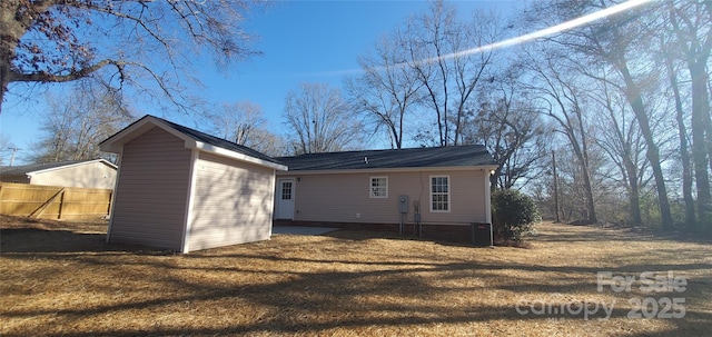 back of house with a lawn, a storage shed, and central AC