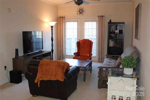 carpeted living room featuring ceiling fan and ornamental molding