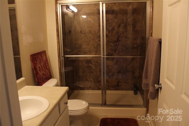 bathroom with tile patterned flooring, toilet, walk in shower, and vanity