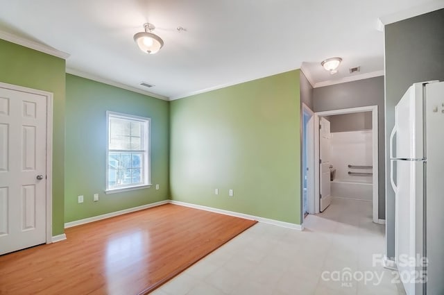 unfurnished bedroom with white refrigerator, ornamental molding, and light hardwood / wood-style floors