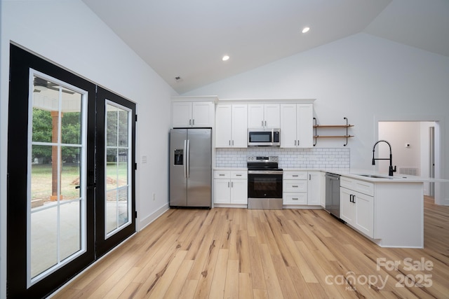 kitchen with white cabinetry, appliances with stainless steel finishes, kitchen peninsula, and light wood-type flooring