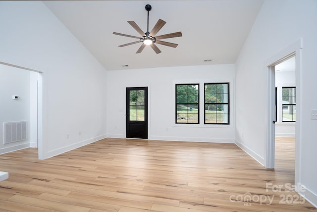 spare room with ceiling fan, high vaulted ceiling, a healthy amount of sunlight, and light hardwood / wood-style floors