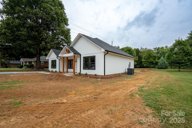 view of front of home featuring central AC and a front yard