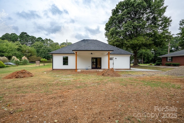 rear view of property featuring a lawn