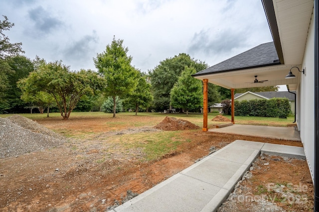 view of yard featuring ceiling fan and a patio