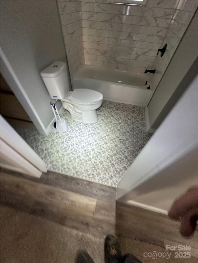 bathroom featuring toilet and a washtub