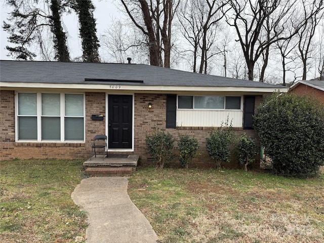 single story home featuring a front lawn