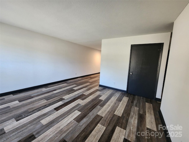 empty room featuring dark hardwood / wood-style flooring and a textured ceiling