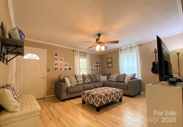 living room with crown molding, ceiling fan, and light hardwood / wood-style floors