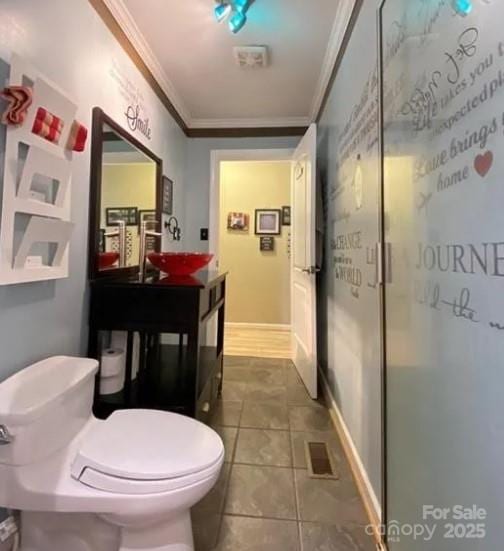 bathroom with sink, crown molding, tile patterned floors, and toilet