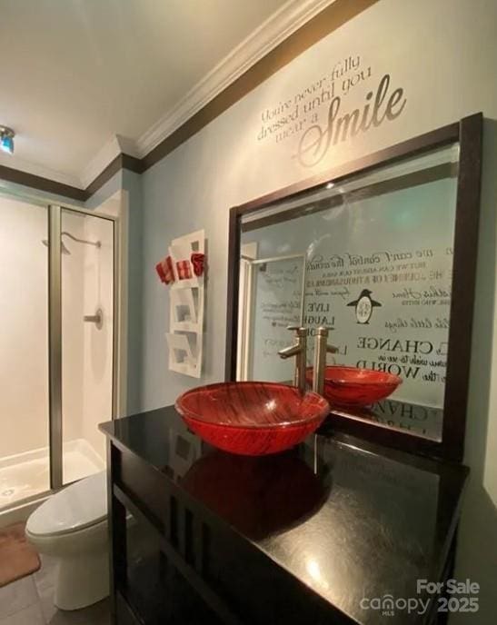 bathroom with toilet, a shower with shower door, crown molding, vanity, and tile patterned flooring