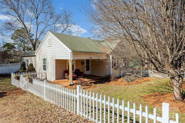 view of front of house with fence private yard, a front lawn, and roof with shingles