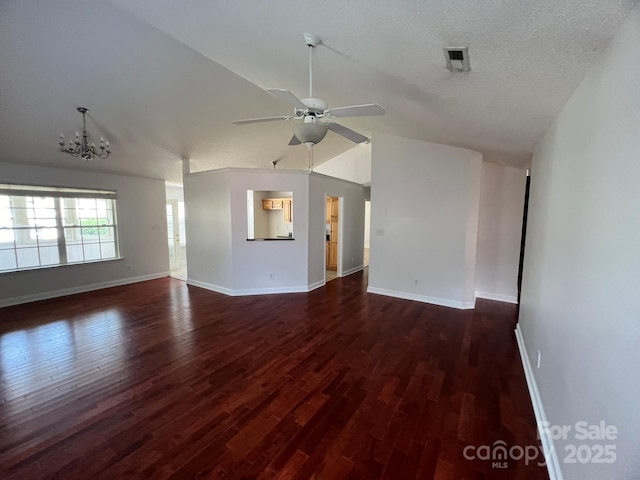 unfurnished living room featuring dark hardwood / wood-style flooring, ceiling fan with notable chandelier, vaulted ceiling, and a textured ceiling