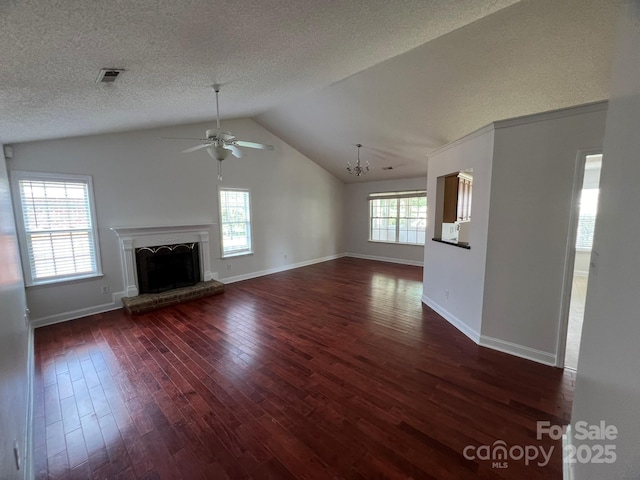 unfurnished living room featuring dark wood-type flooring, vaulted ceiling, a textured ceiling, ceiling fan, and a fireplace