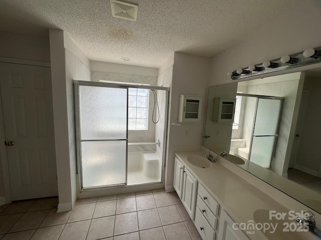 bathroom with tile patterned flooring, vanity, a shower with door, and a textured ceiling