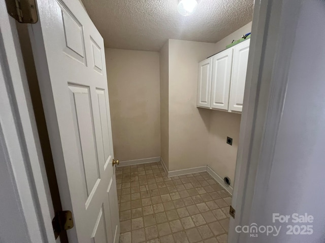 laundry room with cabinets, hookup for an electric dryer, and a textured ceiling