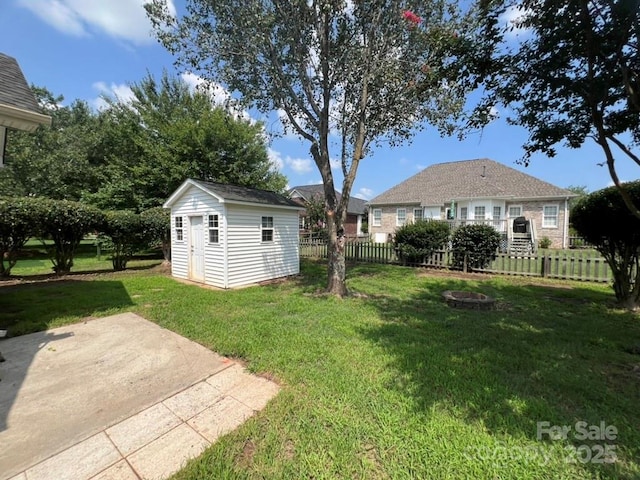 view of yard with a storage shed, a patio, and a fire pit