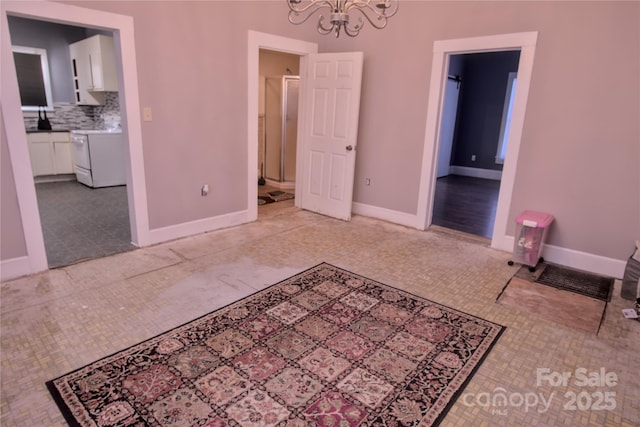 bedroom featuring light tile patterned flooring, ensuite bathroom, and a chandelier