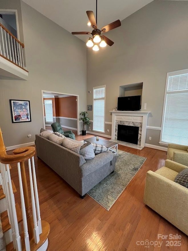 living room with high vaulted ceiling, a healthy amount of sunlight, a fireplace, and hardwood / wood-style floors