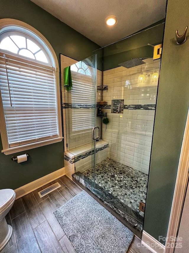 bathroom with toilet and walk in shower