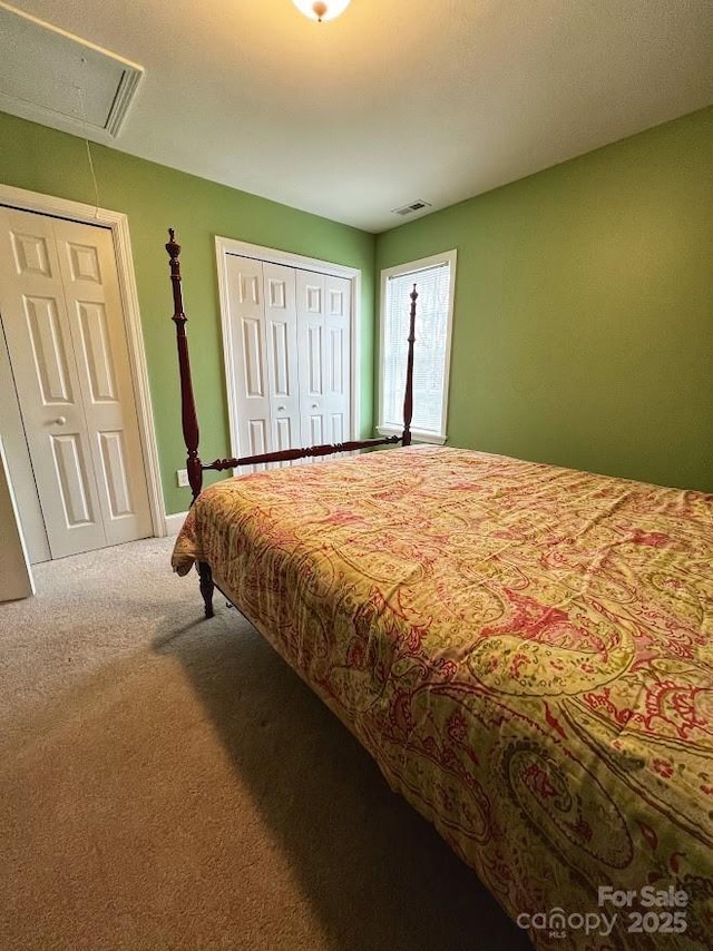 bedroom featuring carpet flooring and two closets