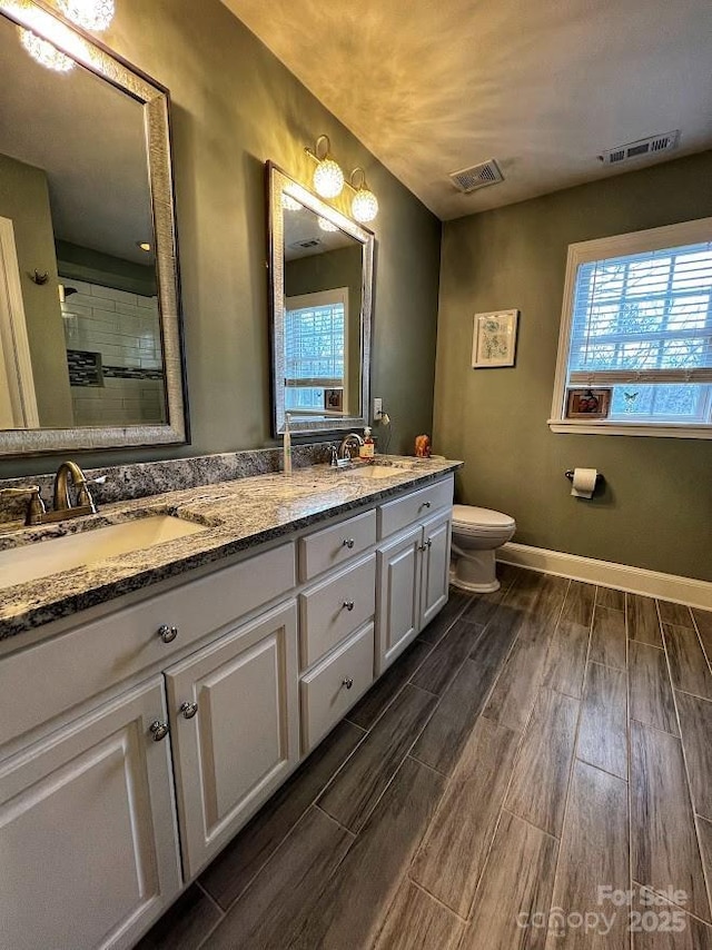 bathroom featuring toilet, vanity, and walk in shower