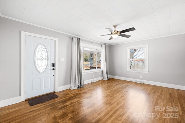 foyer featuring hardwood / wood-style flooring, ornamental molding, and ceiling fan