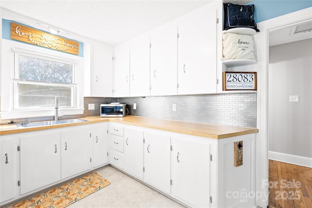 kitchen with white cabinetry, sink, and backsplash